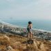 Woman standing on a rock overlooking a beach town in Central California