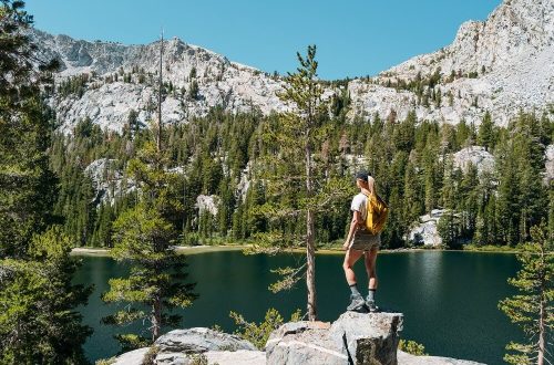 Woman standing on a rock overlooking a lake in Inyo National Forest